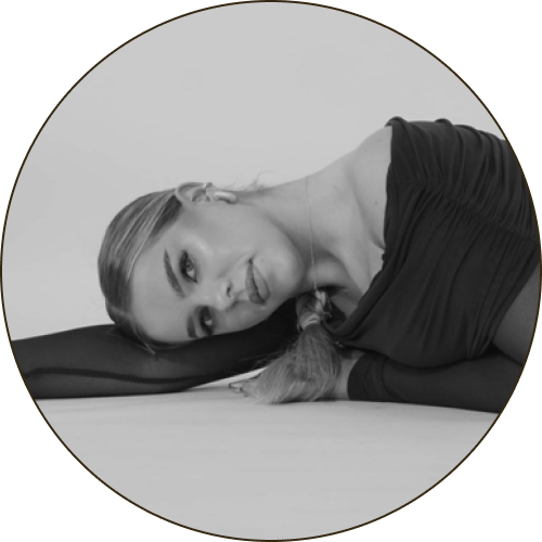 Portret kobiety leżącej na boku, uśmiechniętej.