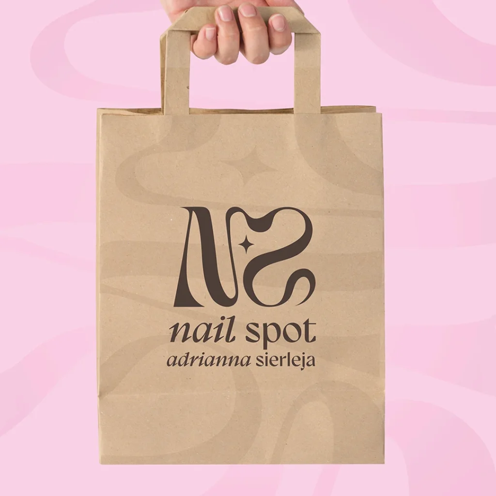 Beżowa torba papierowa z logo „Nail Spot”.