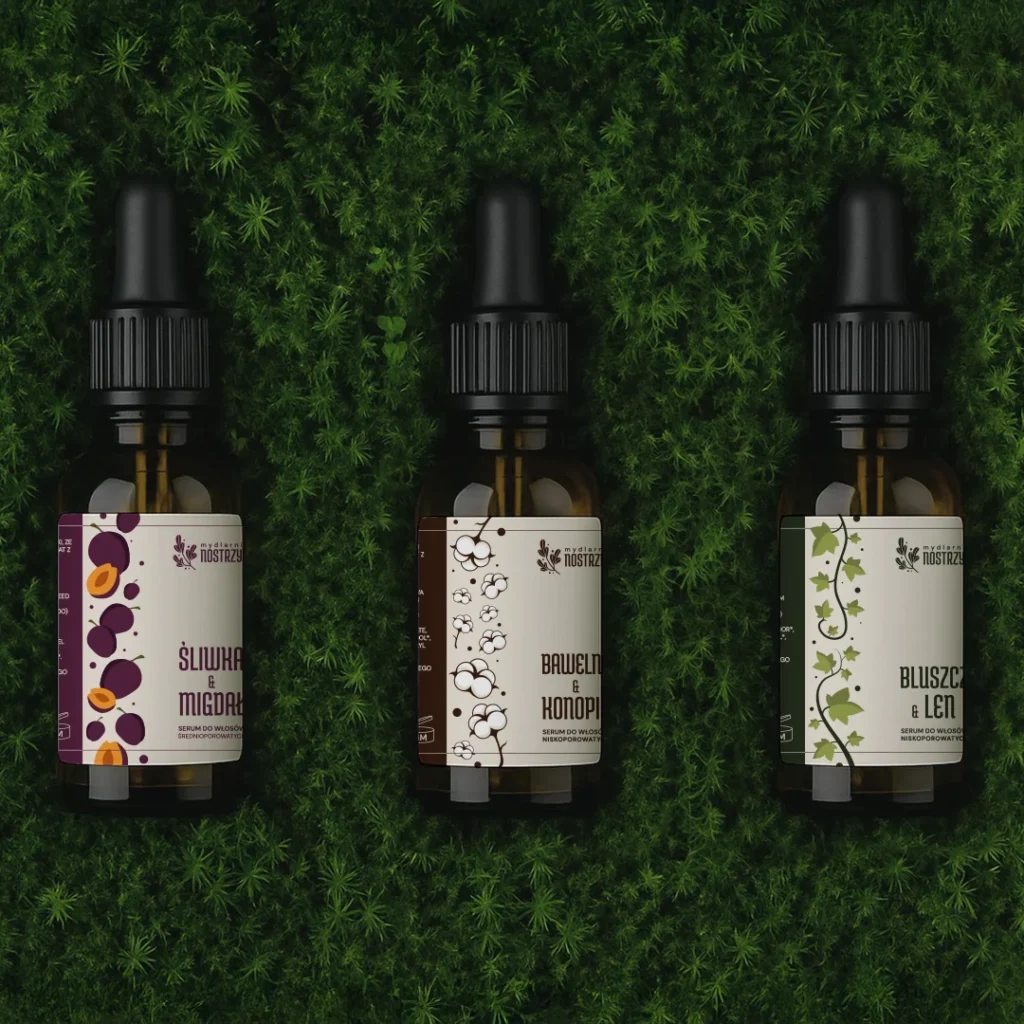 Trzy olejki leżące na tle zieleni.