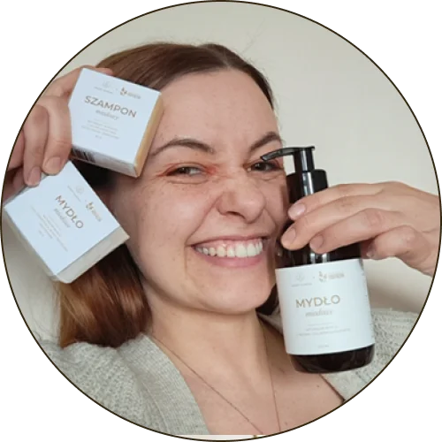 Kobieta uśmiechnięta, trzymająca trzy kosmetyki w dłoniach