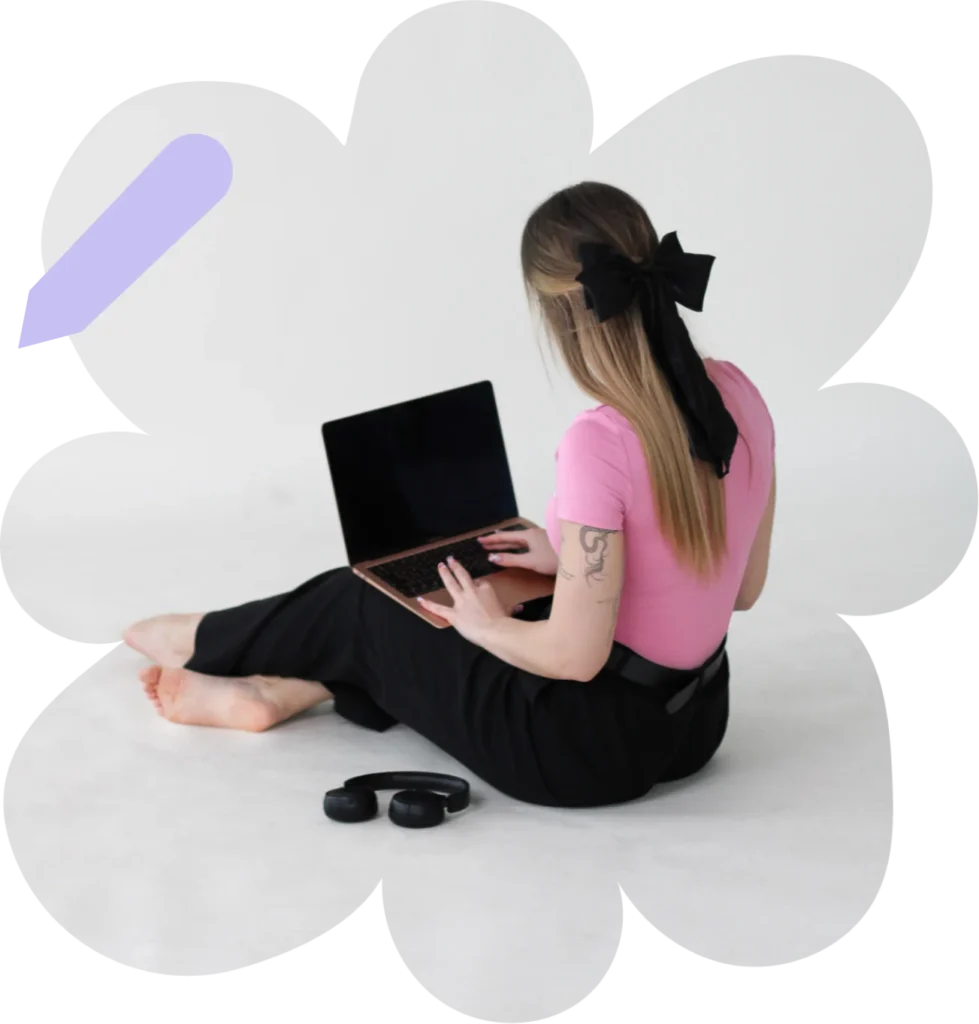 Kobieta siedząca na podłodze z laptopem, na białym tle z kwiatową grafiką